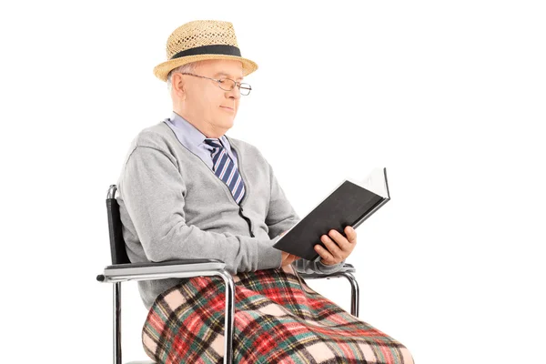 Homem leitura livro sentado em cadeira de rodas — Fotografia de Stock