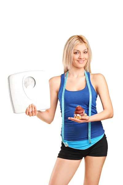 女人抱着体重秤和蛋糕 — 图库照片