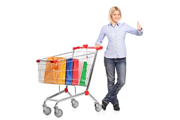 Woman with shopping cart giving thumb up — Stock Photo, Image