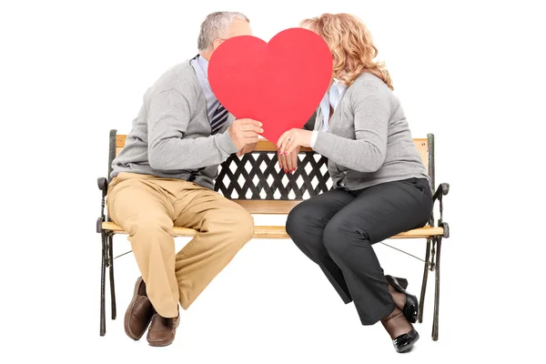 Elderly couple chatting behind heart — Stock Photo, Image