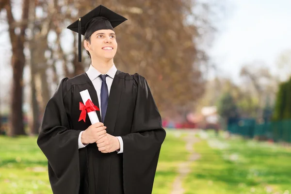 Proud college graduate holding diploma — Stock Photo, Image