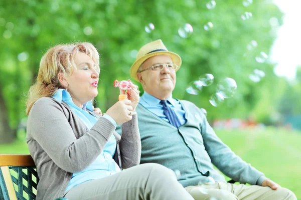 Mature couple blowing bubbles — Stock Photo, Image