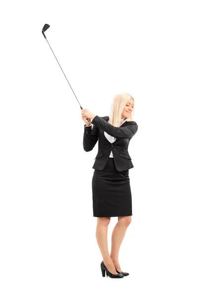 Businesswoman swinging golf club — Stock Photo, Image