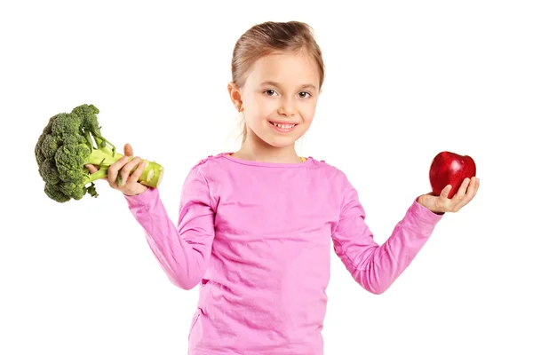 Girl holding broccoli and apple — Stock Photo, Image