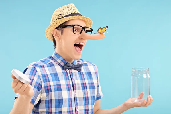 Homem aprisionando borboleta em frasco — Fotografia de Stock