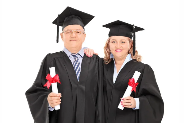 Äldre par i examen kappor — Stockfoto