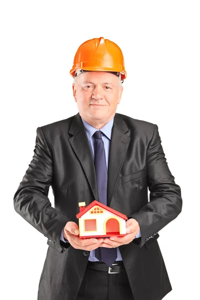 Ingeniero maduro sosteniendo pequeña casa — Foto de Stock