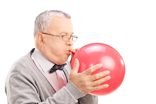 Volwassen man opblazen van de ballon — Stockfoto
