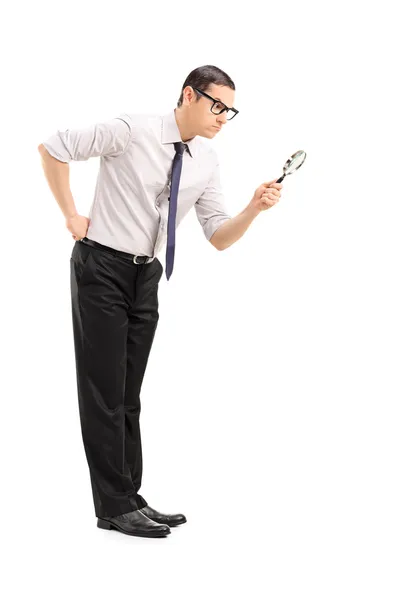 Man looking through magnifying glass — Stock Photo, Image