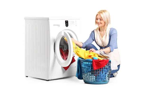 Mulher esvaziando máquina de lavar roupa — Fotografia de Stock