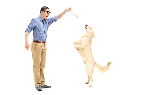Young man luring dog — Stock Photo, Image