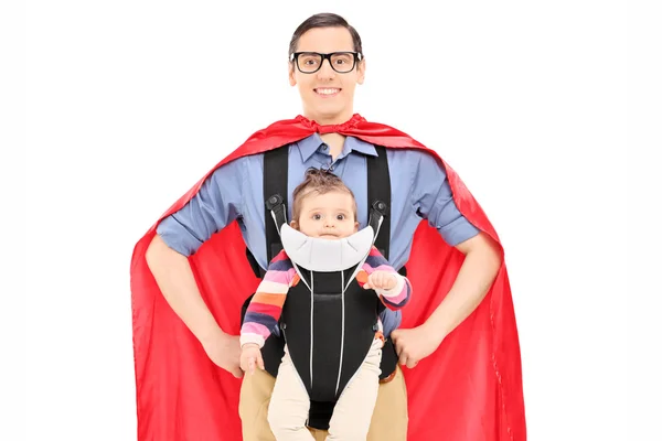 Bebek kızı taşıyan süper kahraman — Stok fotoğraf