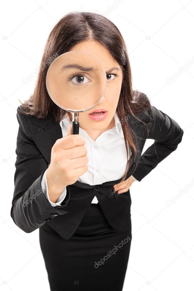 Businesswoman looking through magnifying glass