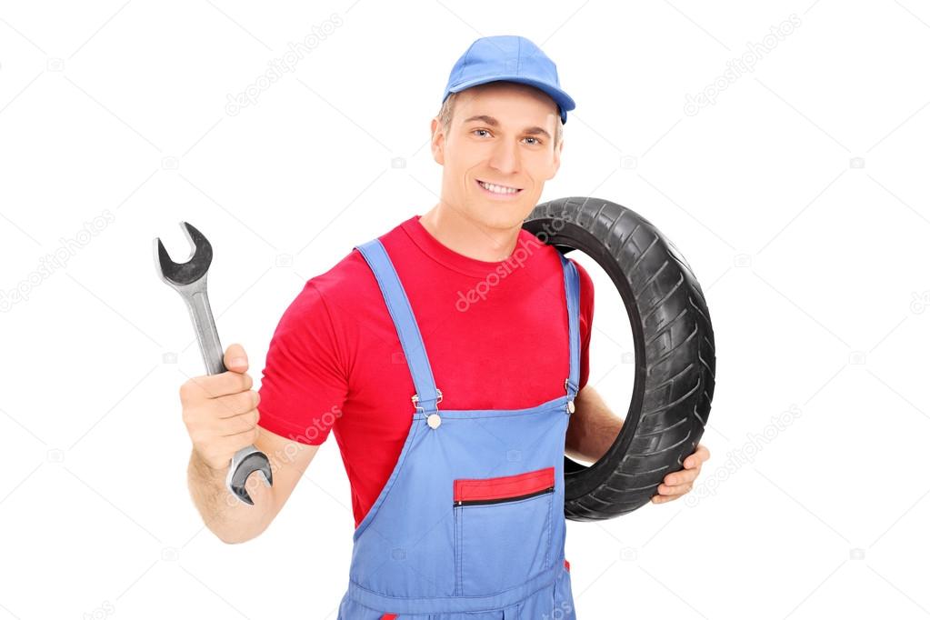 Mechanic holding wrench and tire