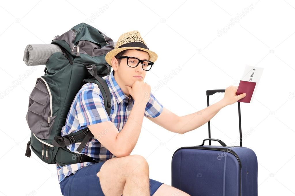 5 часов до поездки. Турист. Турист с чемоданом. Человек с чемоданом. Грустный турист.