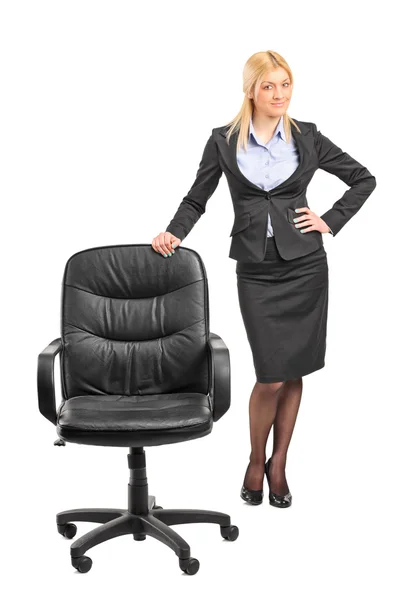 Businesswoman standing by office chair — Stock Photo, Image