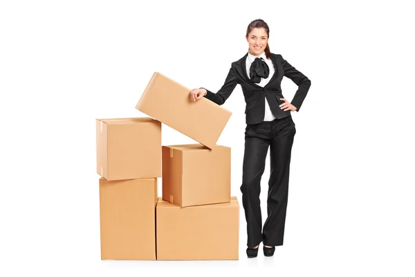 Businesswoman standing next to boxes — Stock Photo, Image