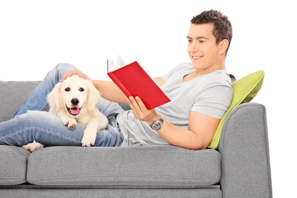 Uomo che legge libro con cucciolo — Foto Stock