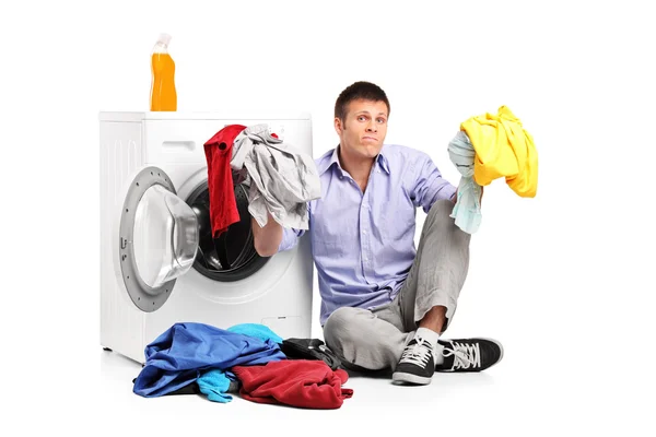 Megzavarodott fiatal ember csinál mosoda — Stock Fotó