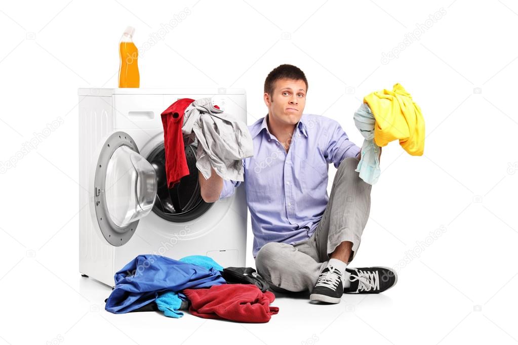 Confused young man doing laundry 