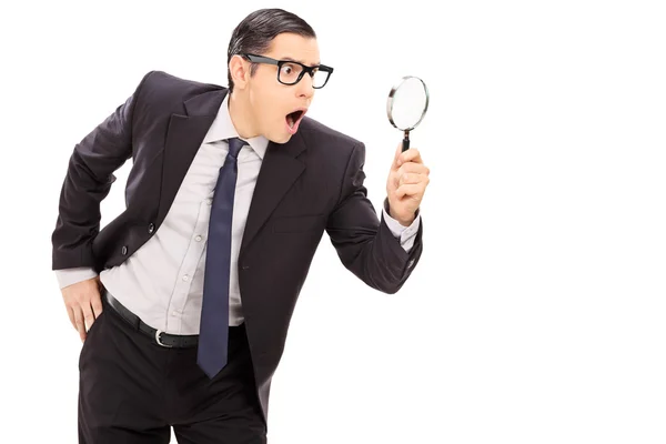 Businessman looking through magnifier — Stock Photo, Image