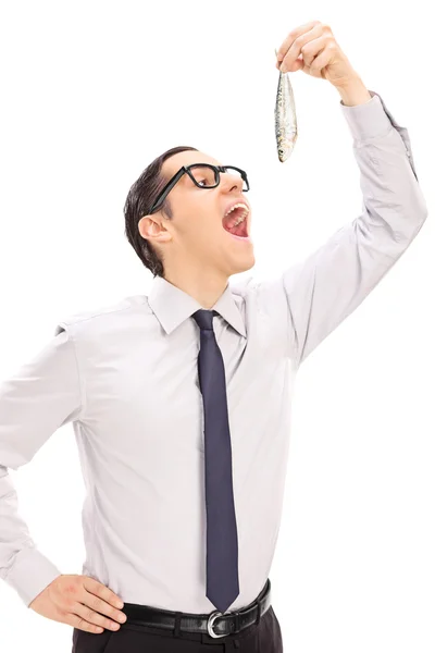 Young man eating small fish — Stock Photo, Image