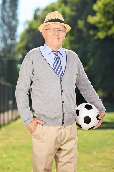 Sênior cavalheiro segurando bola de futebol — Fotografia de Stock