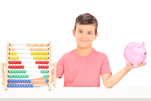 Jongen bedrijf spaarpot en abacus — Stockfoto