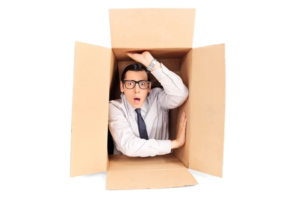 Young businessman trapped in box — Stock Photo, Image