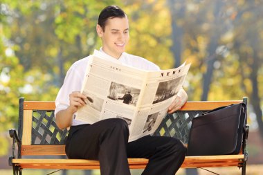 işadamı gazete okuyan bankta