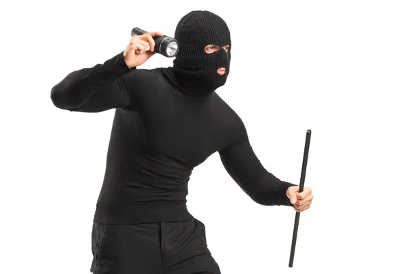 Грабитель в маске держит фонарик — стоковое фото