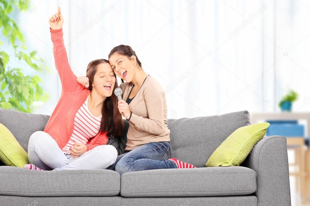 Two sisters singing on microphone