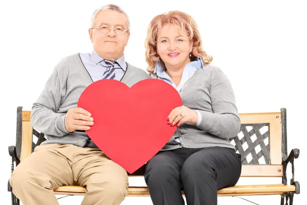 Pareja madura sosteniendo el corazón rojo — Foto de Stock