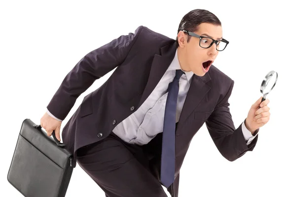 Businessman looking through magnifying glass — Stock Photo, Image