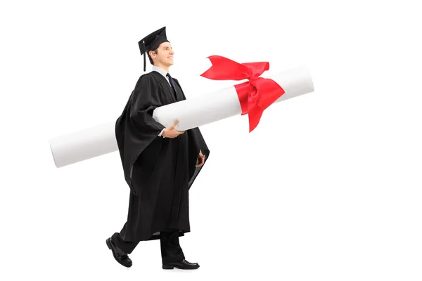 Estudiante graduado llevando un diploma enorme — Foto de Stock