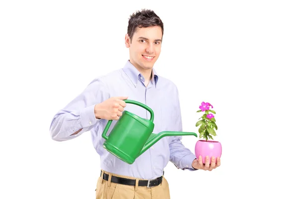 Homem segurando planta e pode — Fotografia de Stock