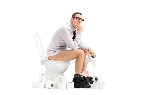 Young man sitting on toilet — Stock Photo, Image