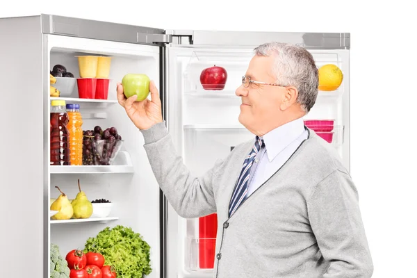 Mann holt Apfel aus Kühlschrank — Stockfoto