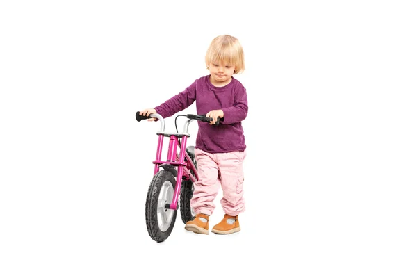 Bebê menina empurrando bicicleta pequena — Fotografia de Stock