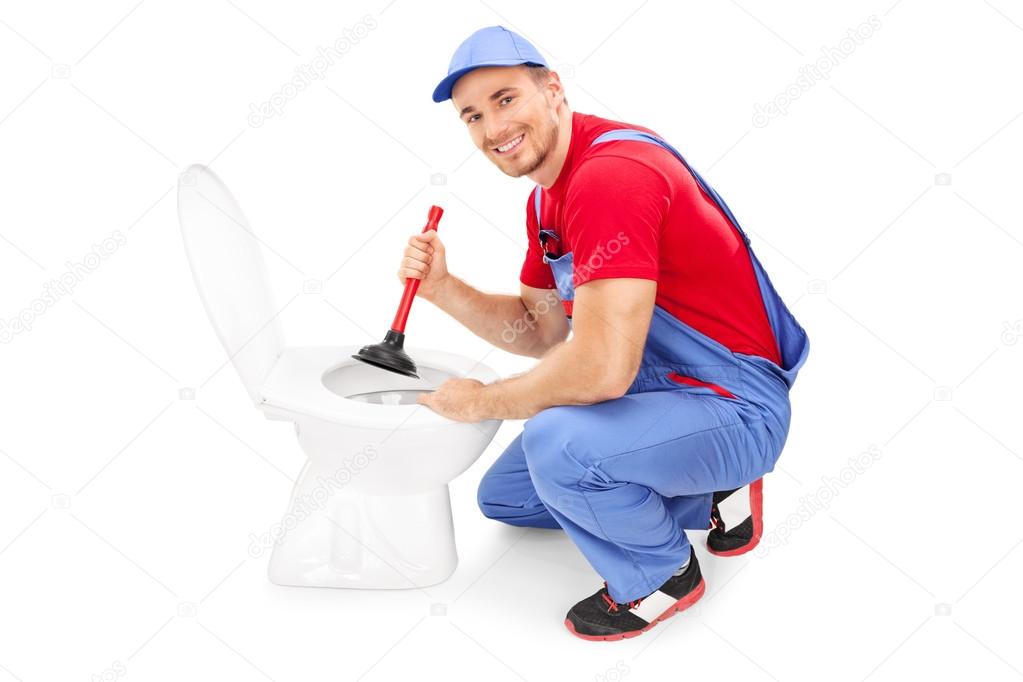 Male plumber unclogging toilet