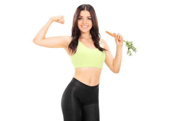 Young woman eating carrot — Stock Photo, Image