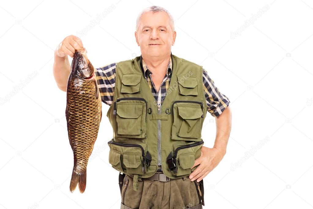 Mature fisherman holding big fish