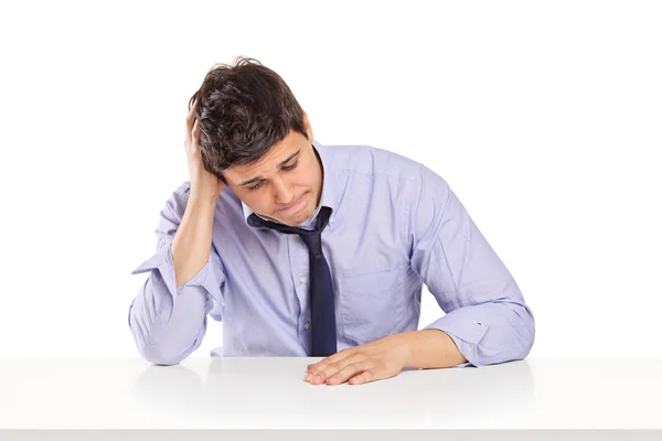 Disappointed man sitting on table — Stock Photo, Image