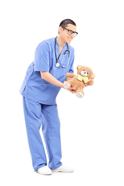 Male doctor giving teddy bear — Stock Photo, Image