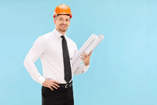 Male architect holding construction plans — Stock Photo, Image