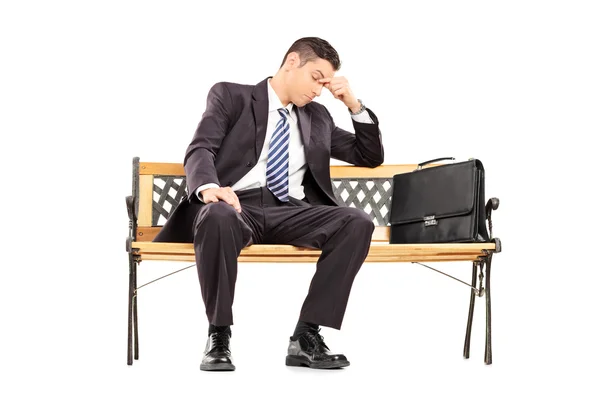 Tired businessman sitting on bench — Stock Photo, Image