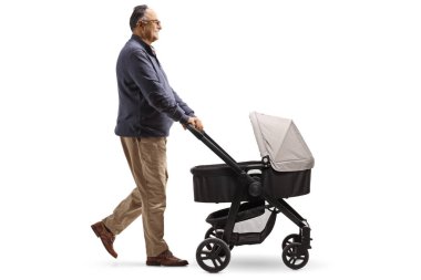 Beyaz arka planda izole edilmiş bir bebek arabasıyla yürüyen olgun bir adamın profil fotoğrafı.