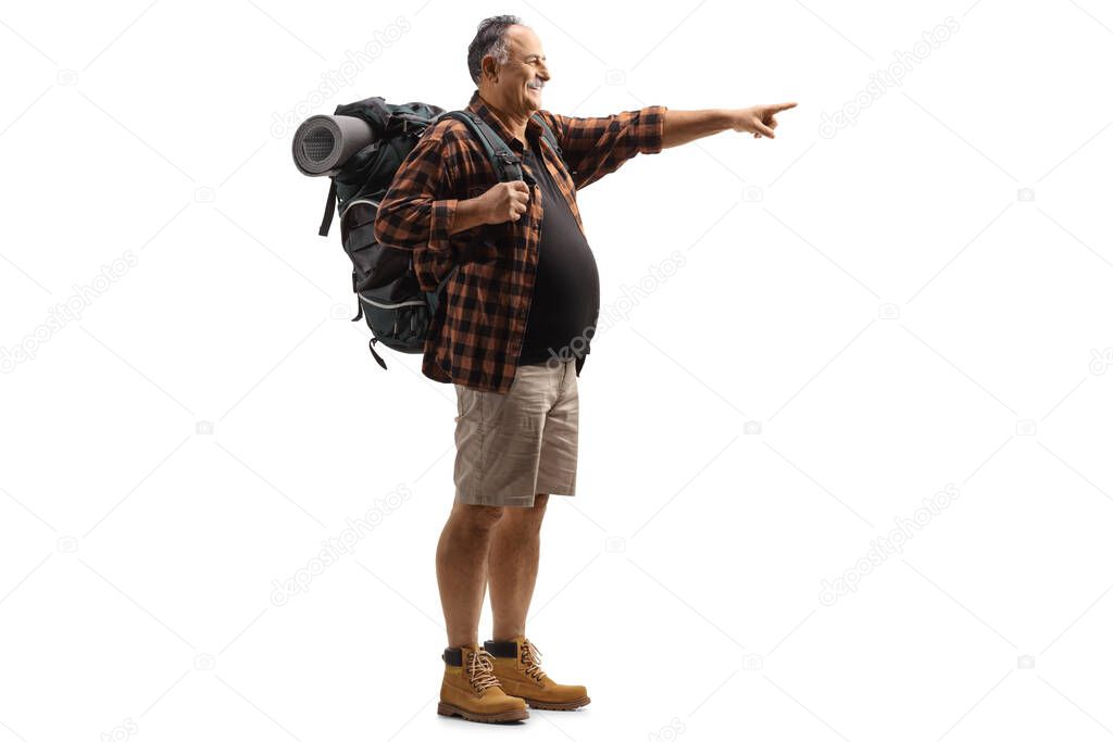 Full length shot of a mature man with hiking equipment pointing isolated on white background