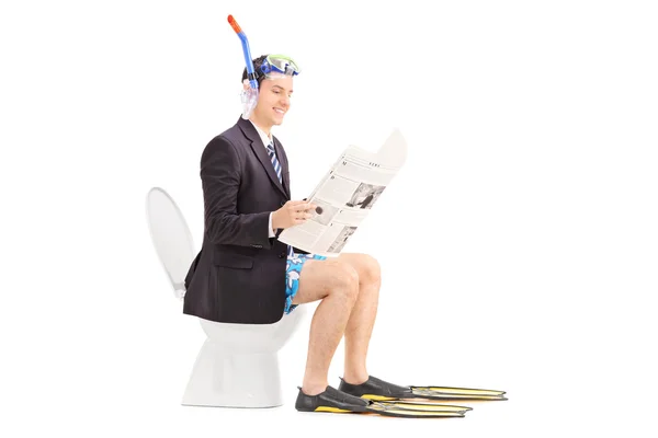 Man reading news on toilet — Stock Photo, Image