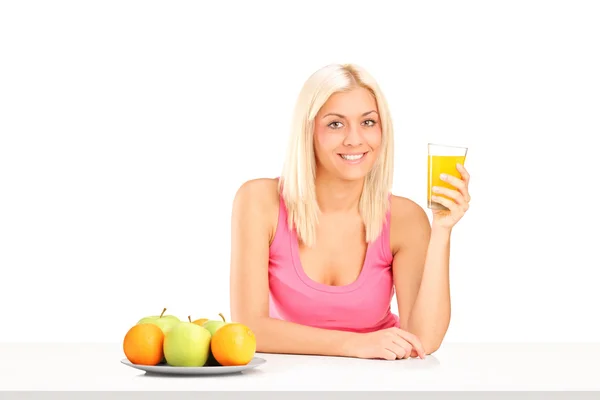 Mulher loira bebendo suco de laranja — Fotografia de Stock